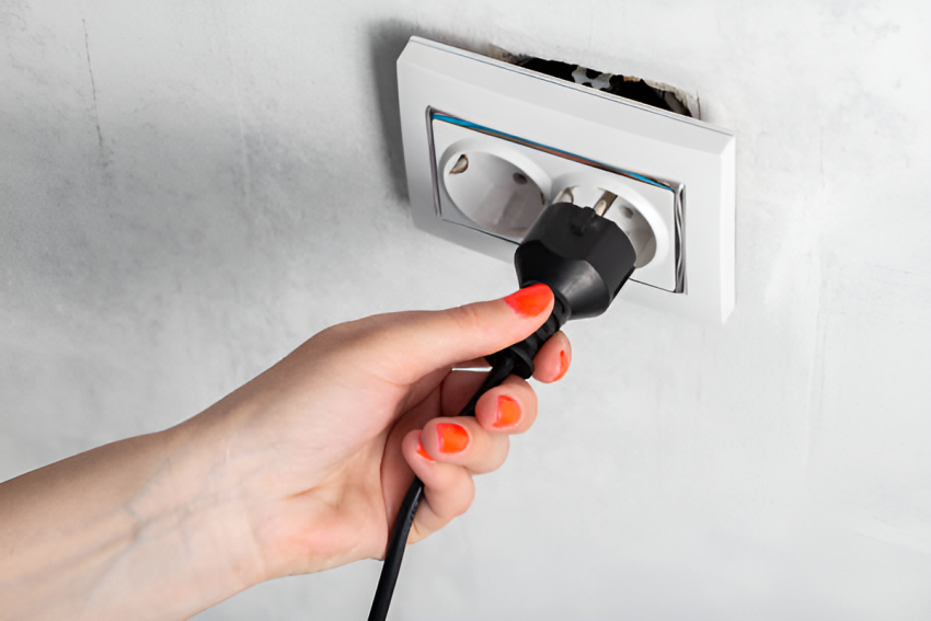 woman putting a plug into a loose outlet